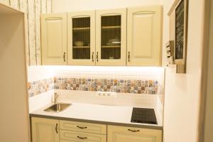 a kitchen with white cabinets and a sink at All In Apartman III. in Budapest