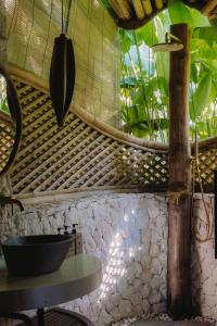 a black bowl on a table in a room with plants at Mandala Eco Resort Lombok in Selong Belanak +83 photos