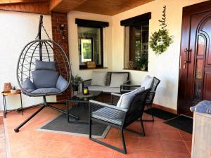 a porch with two chairs and a swing at Ferienhaus an den Eichen in Aschersleben