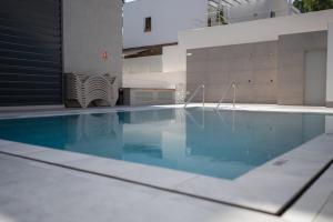 a swimming pool with blue water in a building at Letplanet Playa Park in Torremolinos
