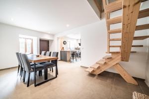 a dining room with a table and chairs and a staircase at Cosy House in Sillingy