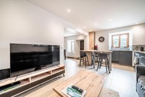 a living room with a large flat screen tv at Cosy House in Sillingy