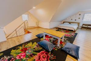 a attic room with two beds and a rug at Casa Boierului (Viscauti) in Vîşcăuţi