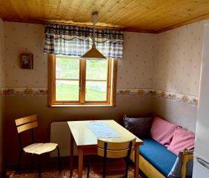 a room with a table and a couch and a window at Ytterbo in Hultsfred