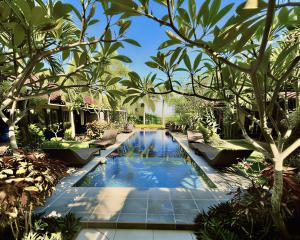 a swimming pool in the middle of a garden at Ombak Resort at Ekas , a luxury surf and kite destination, Close to Inside Ekas beach in Ekas +45 photos