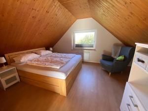 a bedroom with a bed and a window and a chair at Ferienhaus Paschelke in Friedrichskoog-Spitze