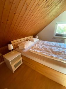 a bed in a room with a wooden ceiling at Ferienhaus Paschelke in Friedrichskoog-Spitze
