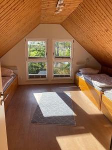 a attic room with two beds and two windows at Ferienhaus Paschelke in Friedrichskoog-Spitze +5 photos