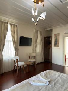 a bedroom with a bed and a table and a tv at Şah Bey Konağı in Istanbul