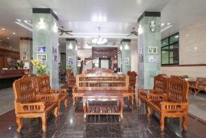 a room with wooden chairs and a table in it at Onnicha Hotel Phuket in Phuket