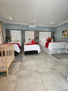 a bedroom with two beds with white and red sheets at Elitha Boutique Bed and Breakfast in Mogwase
