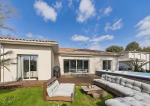 a living room with a couch and a patio at Villa Émeraude Spa in Le Porge