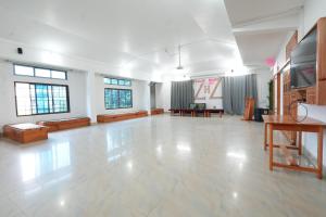 an empty room with a large room with tables and chairs at Hotel Zimin Ziro in Ziro