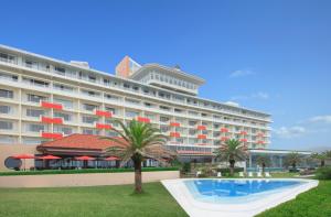 a large hotel with a swimming pool in front of it at Kamogawa Grand Hotel in Kamogawa
