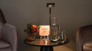 a table with a bottle of wine and glasses on it at Restaurant & Hotel De Jaeger in Ruurlo