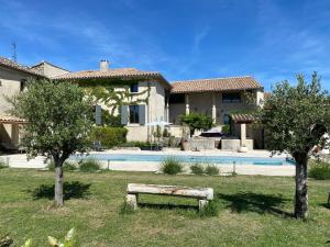 a house with a pool and a bench in the yard at Le mas de Marie in Taulignan