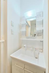 a white bathroom with a sink and a mirror at Cavatina in Sapporo +49 photos