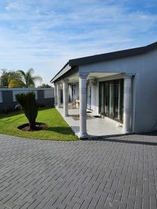 a white house with a porch and a courtyard at Elitha Boutique Bed and Breakfast in Mogwase
