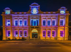 a building lit up in purple and blue at The Opera View Suite in Oamaru