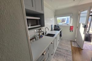 a kitchen with a sink and a microwave at The Opera View Suite in Oamaru