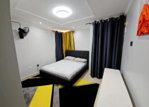 a small room with a bed and curtains at JKIA Transit Hub in Syokimau +23 photos