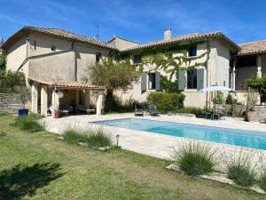 a house with a swimming pool in front of it at Le mas de Marie in Taulignan