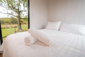 a white bed in a room with a window at Sparkling Tiny House by Tiny Away in Windeyer