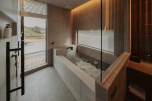 a bathroom with a tub with a water fountain at REQUIES first bloom in Kawazu