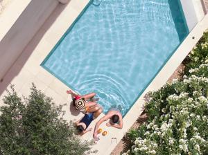 two people are swimming in a swimming pool at Paralos Irini Mare in Agia Galini