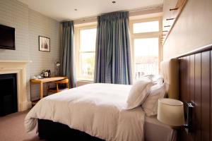 a bedroom with a large white bed and a fireplace at The Wellington in Bristol