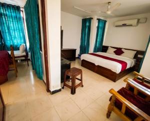 a bedroom with a bed and a couch and a chair at Sree Durga Veerabhoomi Resort in Kushālnagar +197 photos