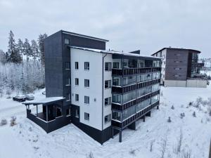 an apartment building in the snow in the winter at Red Apartment 19 in Tahkovuori