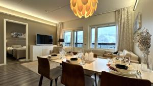 a dining room with a table and chairs and a living room at Red Apartment 19 in Tahkovuori