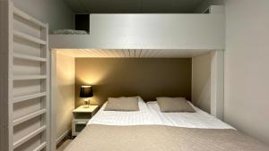 a bedroom with a bed and a night stand with a lamp at Red Apartment 19 in Tahkovuori