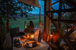 a woman sitting at a table with food on it at Quaint Luxury Villas in Graskop