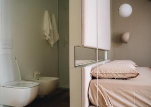 a bathroom with a bed and a toilet and a sink at Mafrica House in Aosta