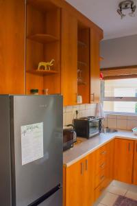 a kitchen with a stainless steel refrigerator and wooden cabinets at Windhoek self accommodation in Windhoek