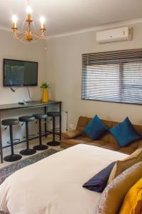 a bedroom with a bed and a desk and a couch at Windhoek self accommodation in Windhoek