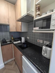 a small kitchen with a sink and a microwave at The Loy Guest Apartment in Cookstown +6 photos