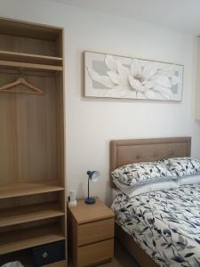 a bedroom with a bed and a flower picture on the wall at The Loy Guest Apartment in Cookstown