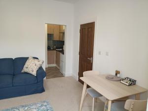 a living room with a blue couch and a table at The Loy Guest Apartment in Cookstown