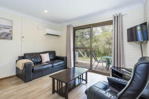 a living room with a couch and a table at Emu Beach Chalets in Albany