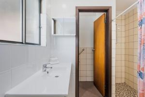 a bathroom with a sink and a mirror at Emu Beach Chalets in Albany +70 photos