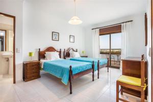a bedroom with two beds and a balcony at Casa Moura in Loulé +18 photos