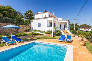 a villa with a swimming pool in front of a house at Casa Moura in Loulé