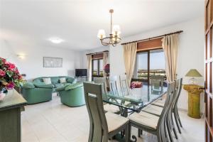 a dining room and living room with a glass table and chairs at Casa Moura in Loulé
