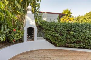 a white walkway with a small tower next to a hedge at Casa Moura in Loulé