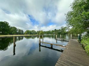 a river with a wooden dock in a park at Siblu Prϋβsee in Güster