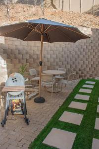 a patio with an umbrella and a table and chairs at Windhoek self accommodation in Windhoek