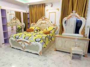 a bedroom with a bed with a dresser and a mirror at P M Serviced Apartments in Lagos
